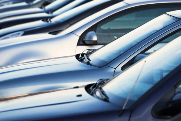 A row of silver cars parked in a lot.